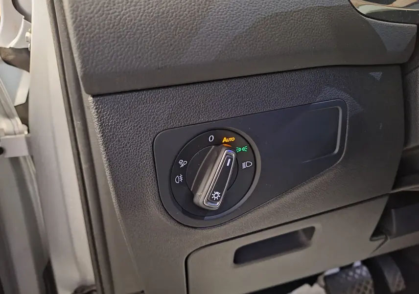 Gros plan sur le commutateur d'éclairage noir du tableau de bord côté gauche du Volkswagen Tiguan gris 2021.