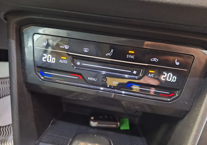 Panneau de climatisation digital du Volkswagen Tiguan gris, affichant 20°C en mode automatique avec fonction SYNC active.