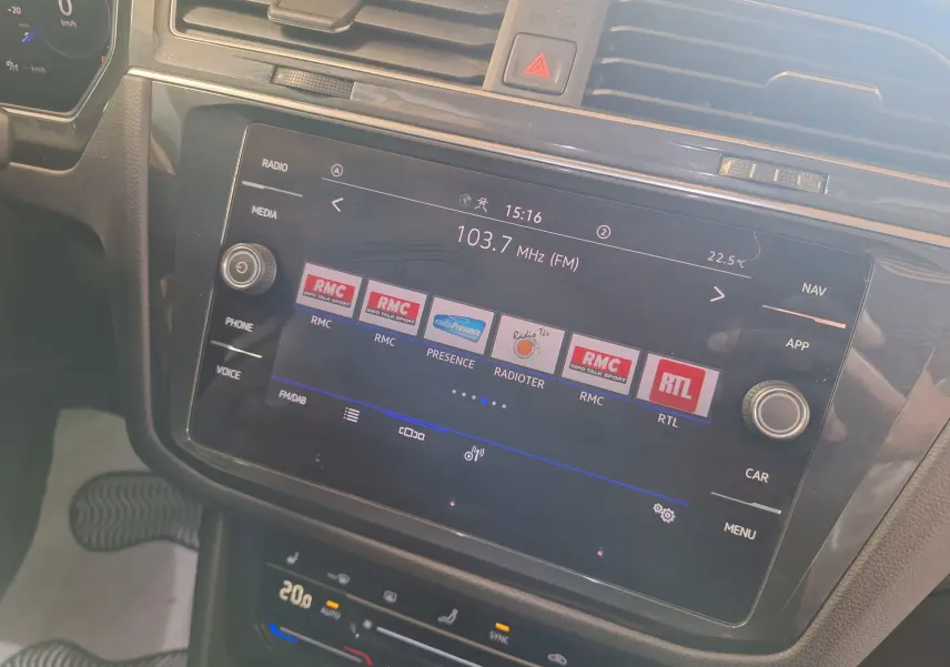 Écran tactile central du Volkswagen Tiguan 2021 affichant les stations radio, avec commandes autour en noir brillant.
