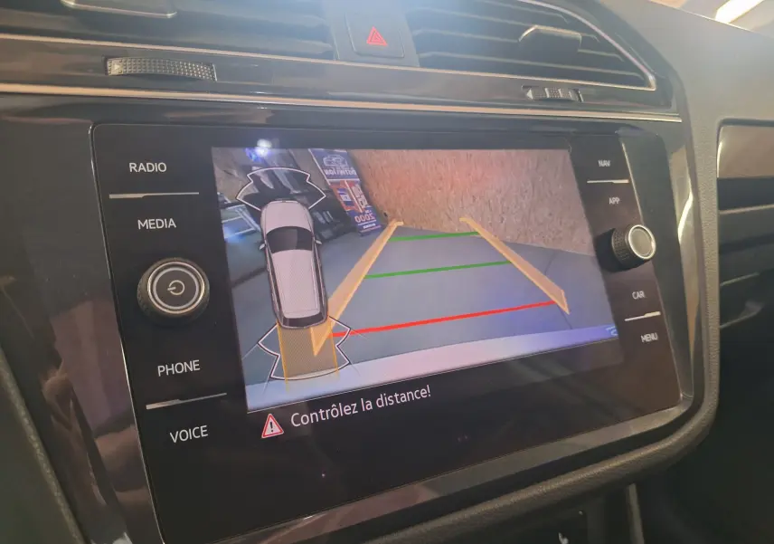 Écran tactile intérieur du Volkswagen Tiguan 2021 montrant la caméra de recul avec guidage de trajectoire coloré.