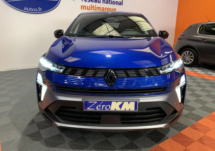 Vue frontale du Renault SYMBIOZ bleu iron avec ses phares LED allumés et la calandre noire distinctive.