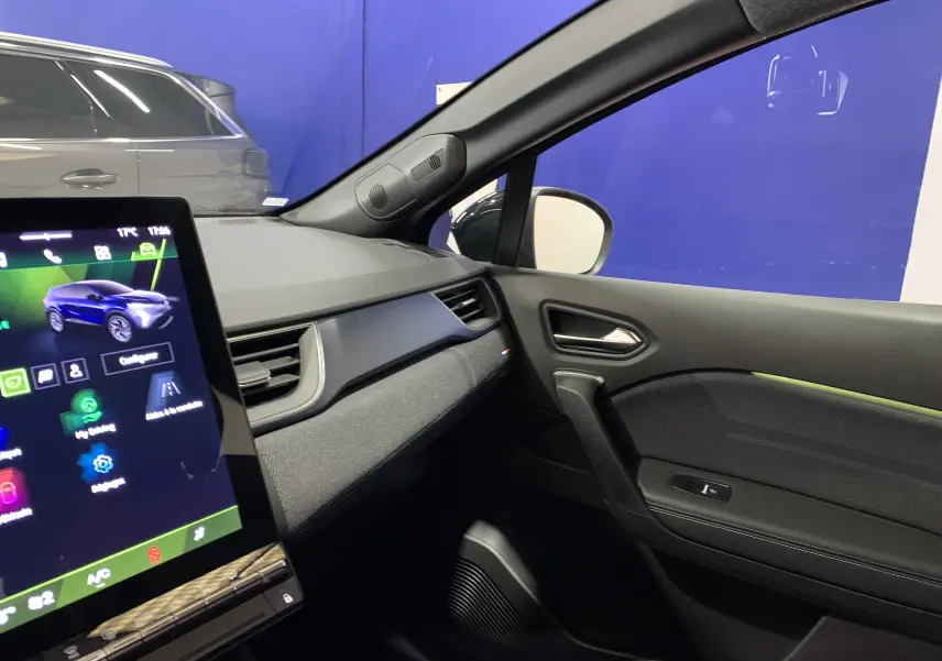 Intérieur côté passager du Renault Symbioz bleu Iron 2025 avec tableau de bord moderne et écran tactile visible.