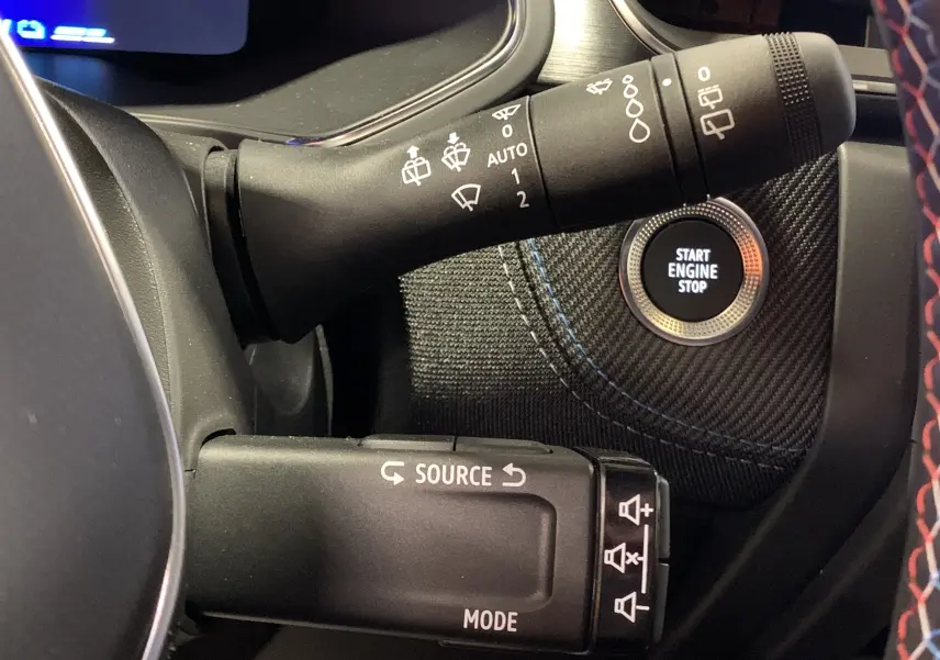 Gros plan sur la commande des essuie-glaces et bouton start dans l’habitacle du Renault Symbioz bleu iron.