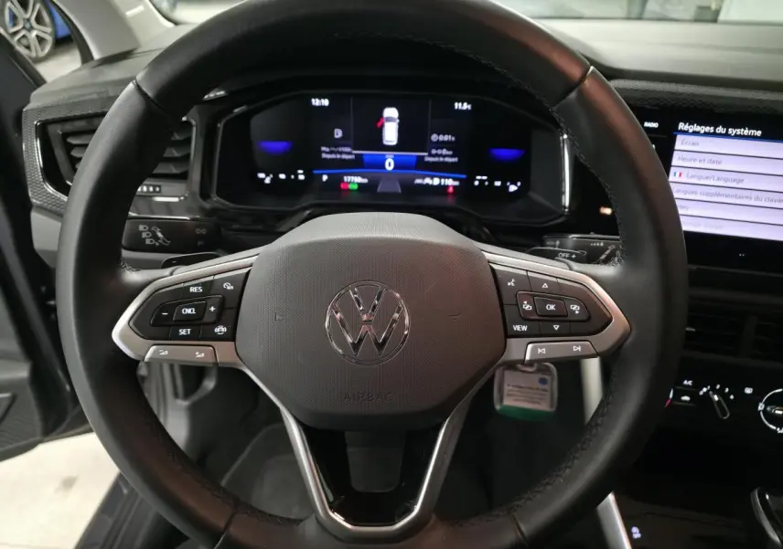 Vue intérieure centrée sur le volant cuir multifonction noir d'une Volkswagen Polo 2025 avec tableau de bord digital.