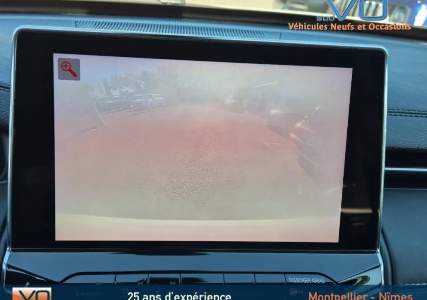 Écran tactile intérieur montrant la caméra de recul du Jeep Compass blanc 2023, tableau de bord noir moderne.