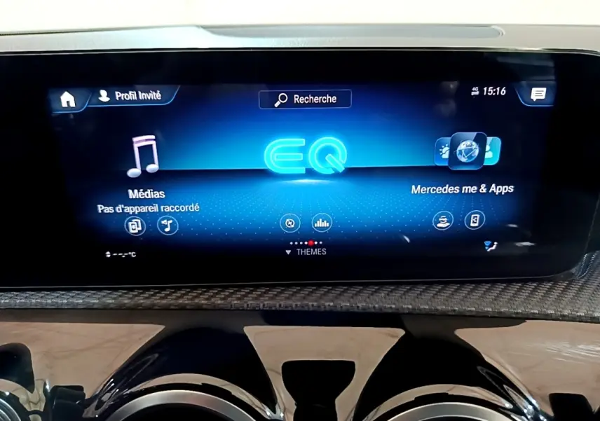 Écran tactile central bleu affichant l'interface Mercedes EQ dans l'habitacle d'une Classe A gris foncé.