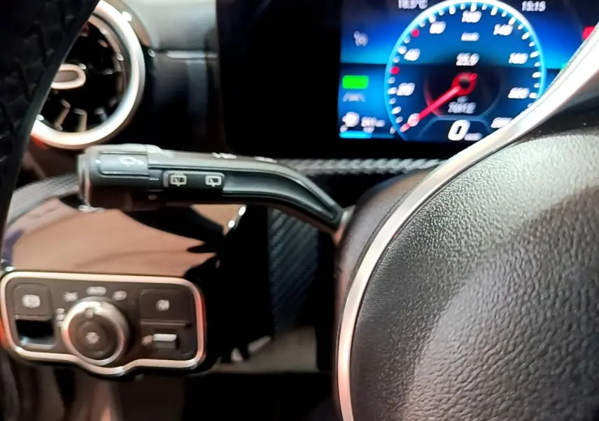 Gros plan sur le volant cuir et le tableau de bord numérique bleu d'une Mercedes Classe A A 250 e Business Line 2020.