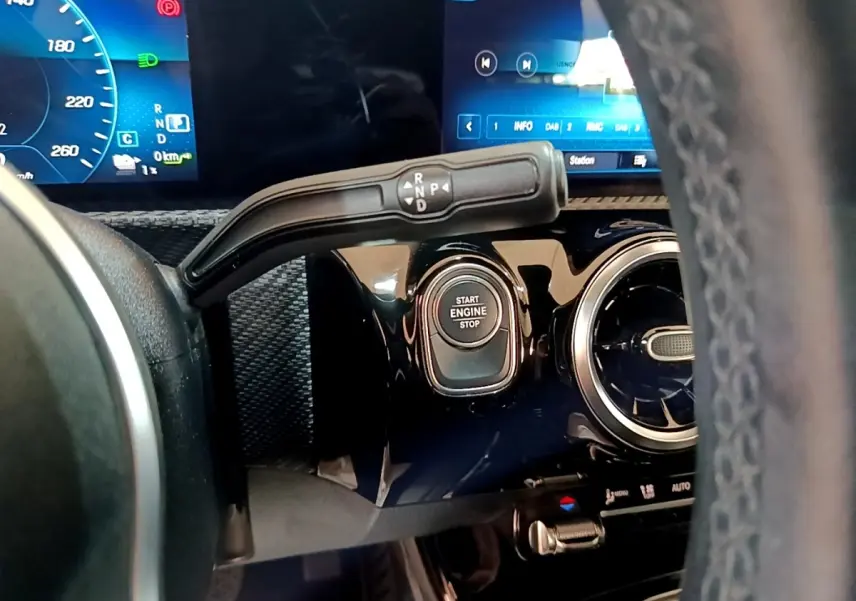Gros plan sur le tableau de bord noir brillant côté gauche d'une Mercedes Classe A 250 e avec bouton Start Engine Stop.