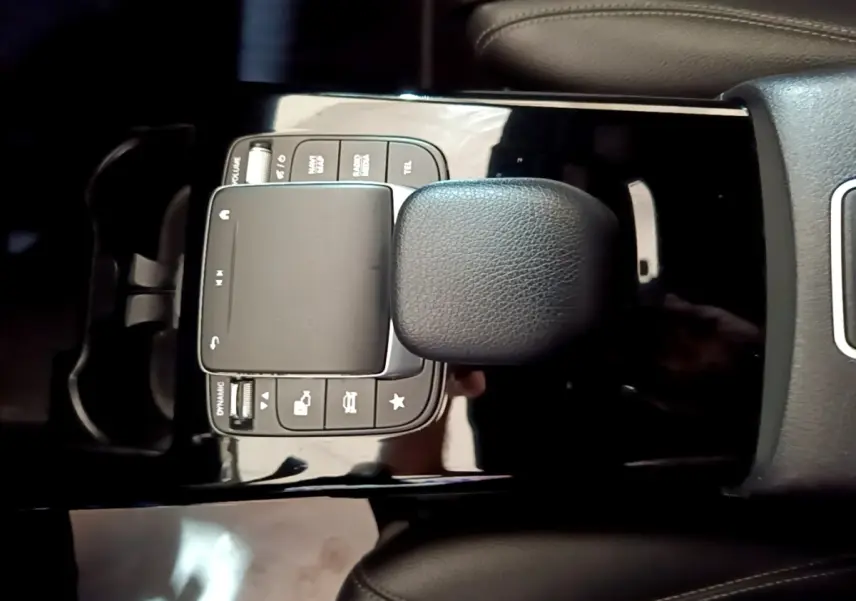 Vue rapprochée du pavé tactile et des commandes noires sur la console centrale d'une Mercedes Classe A gris foncé.