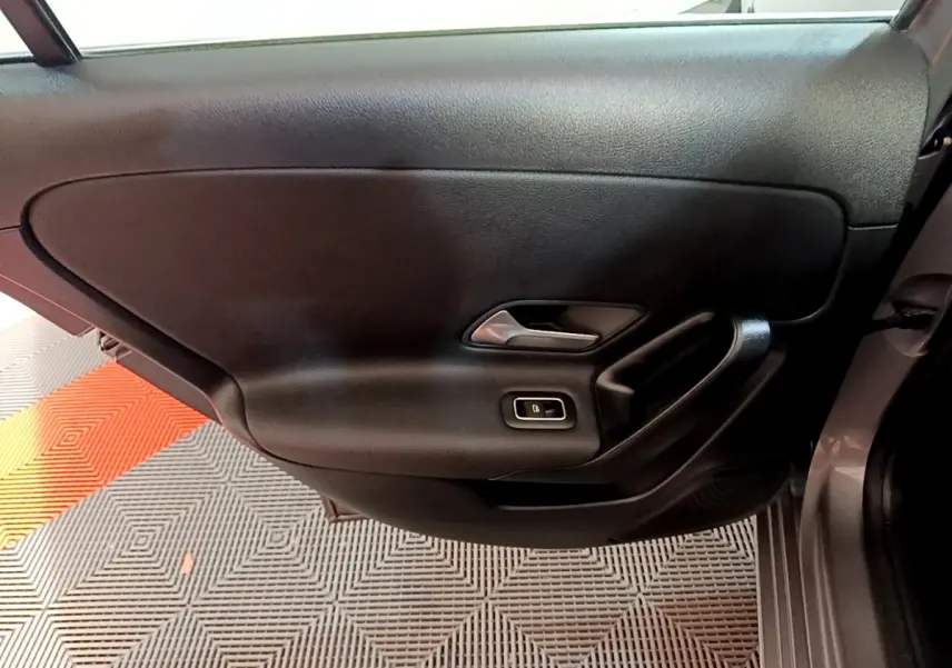 Gros plan sur la porte intérieure côté gauche d'une Mercedes Classe A 250 e Business Line gris foncé avec poignée argentée.