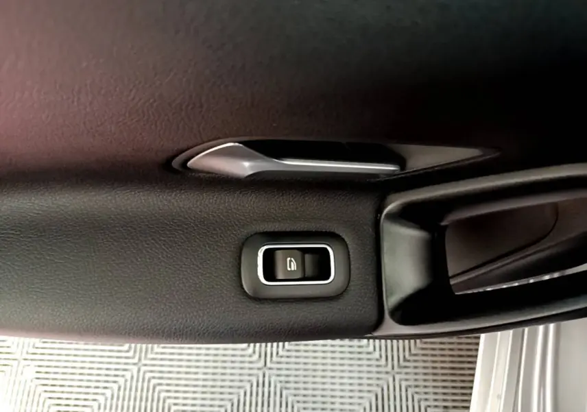 Bouton de verrouillage de porte sur la garniture intérieure côté conducteur d'une Mercedes Classe A gris foncé.