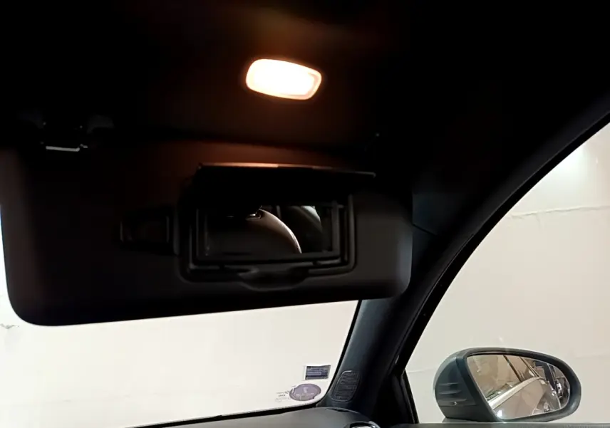 Détail intérieur du pare-soleil avec miroir éclairé et rétroviseur côté droit d'une Mercedes Classe A gris foncé de 2020.