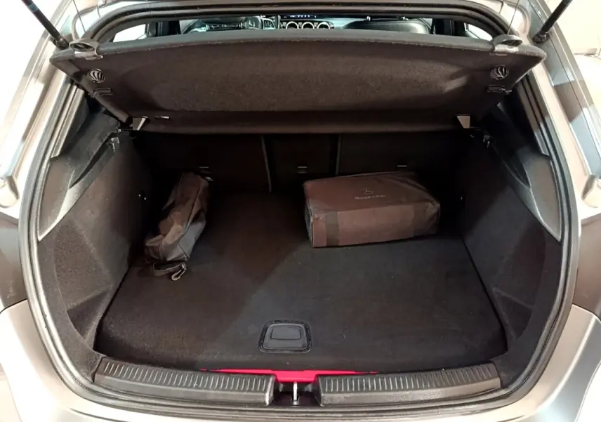 Vue du coffre ouvert d'une Mercedes Classe A 250 e Business Line gris foncé avec sacoche de rangement noire à l'intérieur.