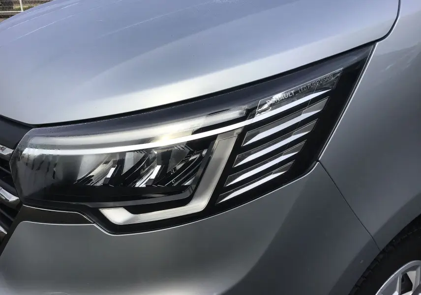 Gros plan sur le phare avant droit LED du Renault Trafic Combi gris clair métal, soulignant son design moderne et épuré.