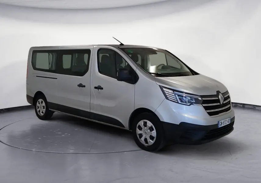 Renault Trafic Combi gris clair métal vu en 3/4 avant droit, avec calandre noire et vitres teintées arrière.