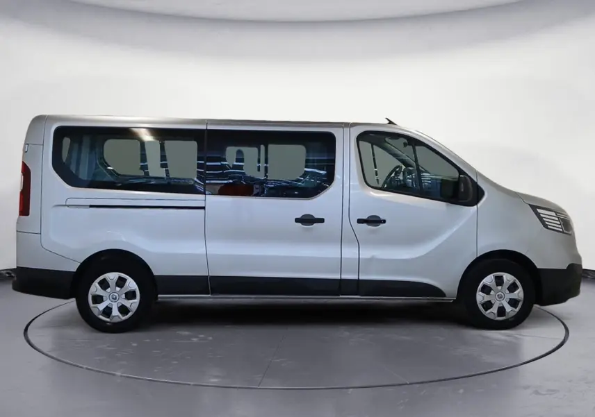 Profil droit d’un Renault Trafic Combi gris clair métal 2023, version L2 9 places avec vitres teintées et jantes acier.