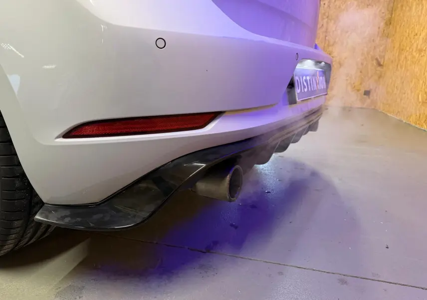 Vue 3/4 arrière droite d'une Volkswagen Golf GTI Performance gris clair avec jantes alu 19 pouces et sorties d'échappement chromées.