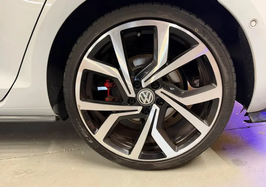 Gros plan sur la partie basse intérieure côté conducteur d'une Volkswagen Golf GTI Performance gris, avec seuil de porte en métal.