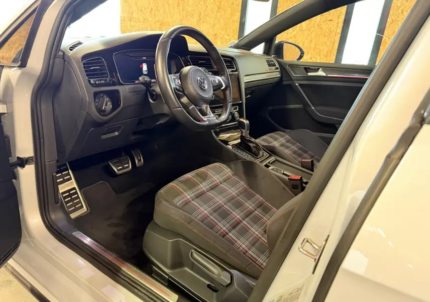 Vue intérieure centrée sur le volant sport noir avec surpiqûres rouges de la Volkswagen Golf GTI Performance gris 2018.