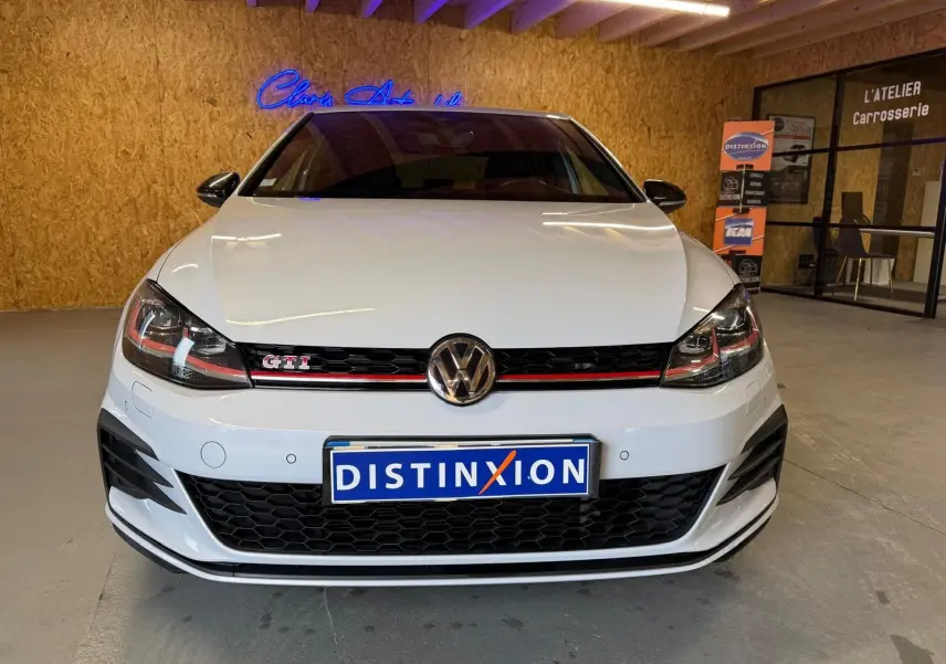 Vue 3/4 avant d'une Volkswagen Golf GTI Performance 2018 blanche avec jantes alu 19'' et étriers de freins rouges.