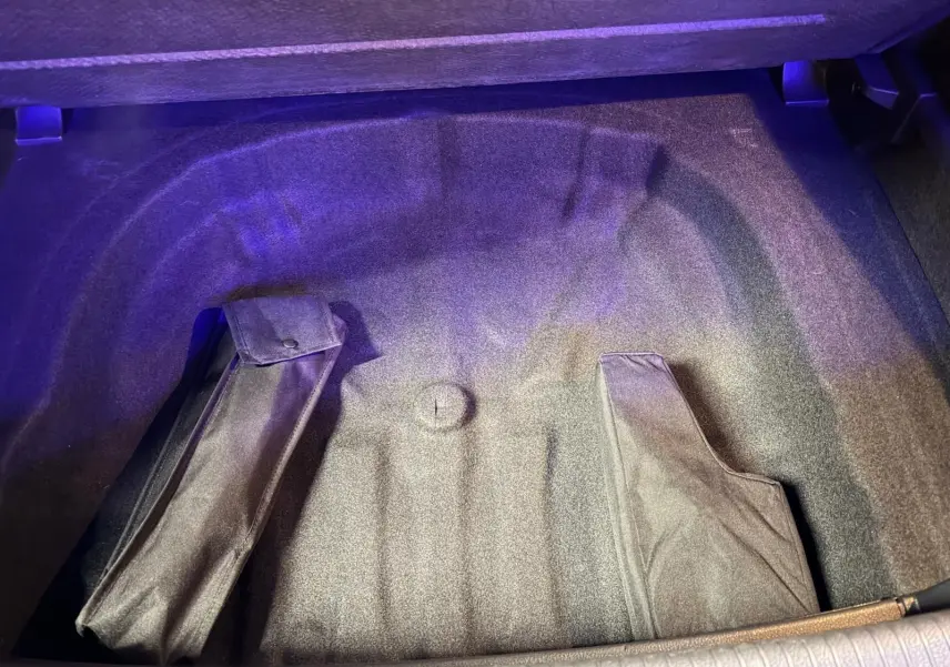 Vue intérieure arrière de la Volkswagen Golf GTI gris, montrant les sièges sport avec tissu à motif écossais et surpiqûres rouges.