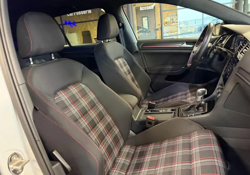 Gros plan sur l'arrière droit gris d'une Volkswagen Golf GTI Performance, avec sortie d'échappement chromée visible.