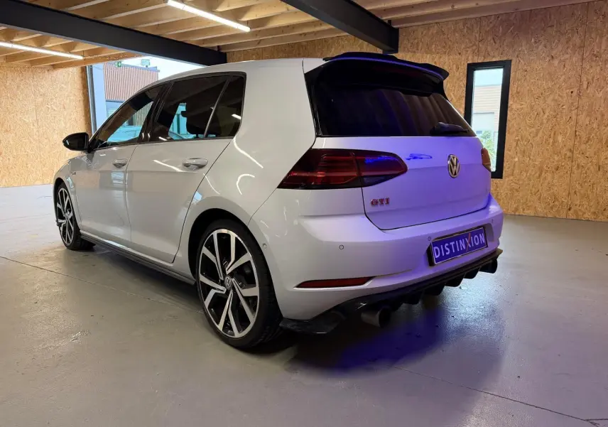 Gros plan sur la jante alu 19'' bicolore et l'étrier de frein rouge d'une Volkswagen Golf GTI Performance gris clair.