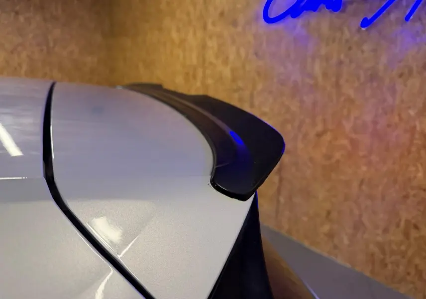 Vue 3/4 arrière droite d'une Volkswagen Golf GTI Performance gris clair avec jantes alu 19'' et sorties d'échappement chromées.