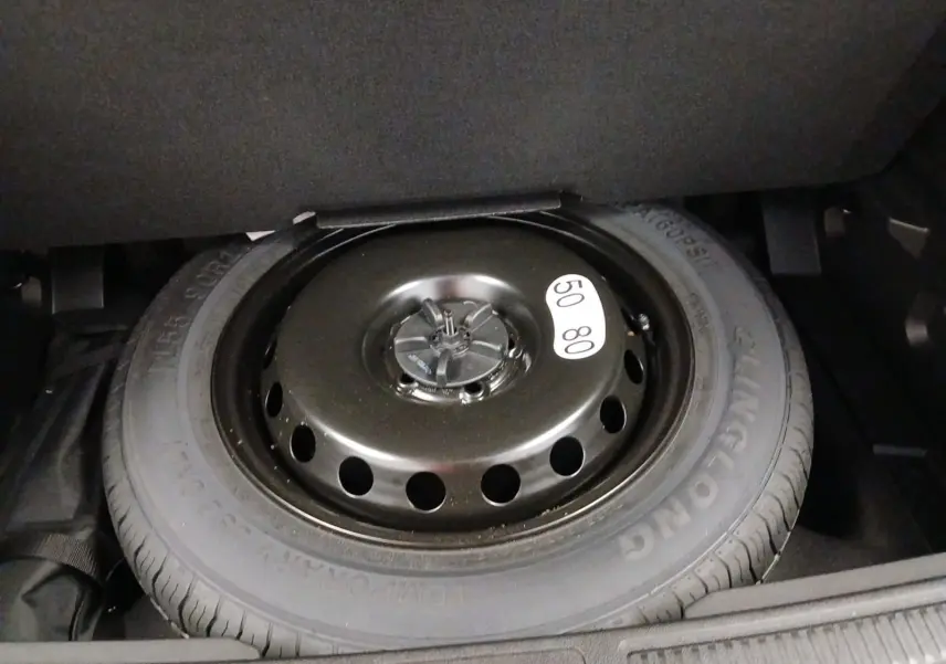 Gros plan sur la roue de secours temporaire noire dans le coffre du Renault Austral 2024 hybride.