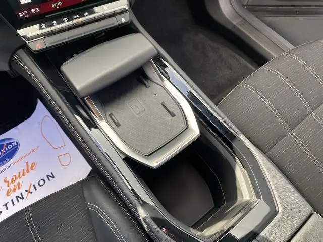 Vue rapprochée de la console centrale du Renault Austral gris schiste, avec chargeur à induction et sellerie tissu gris.