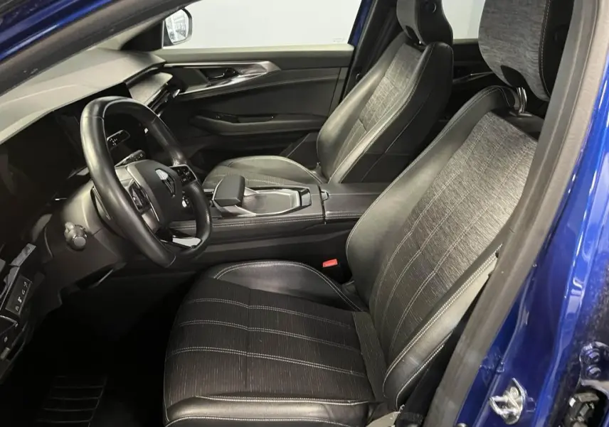 Vue intérieure côté conducteur du Renault Austral bleu, sièges en simili-cuir et tissu gris avec surpiqûres argentées.