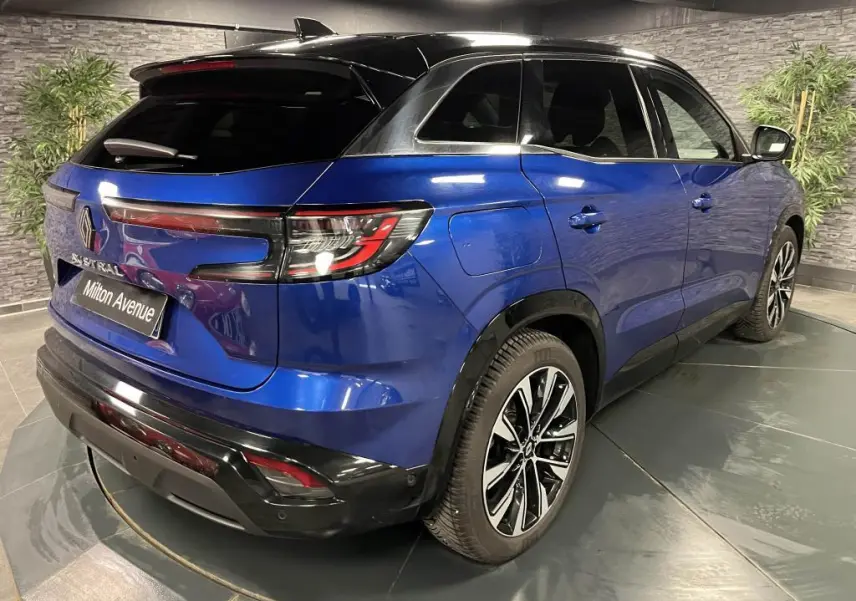 Vue 3/4 arrière droite du Renault Austral bleu avec toit noir étoilé et jantes alliage noires diamantées.