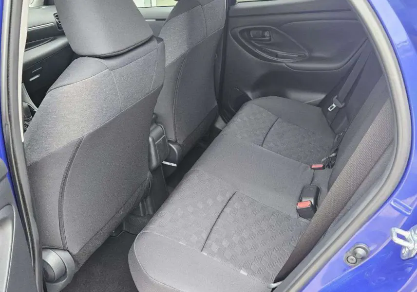 Vue intérieure arrière côté droit de la Toyota Yaris 2025 bleu genièvre, montrant les sièges arrière en tissu gris.