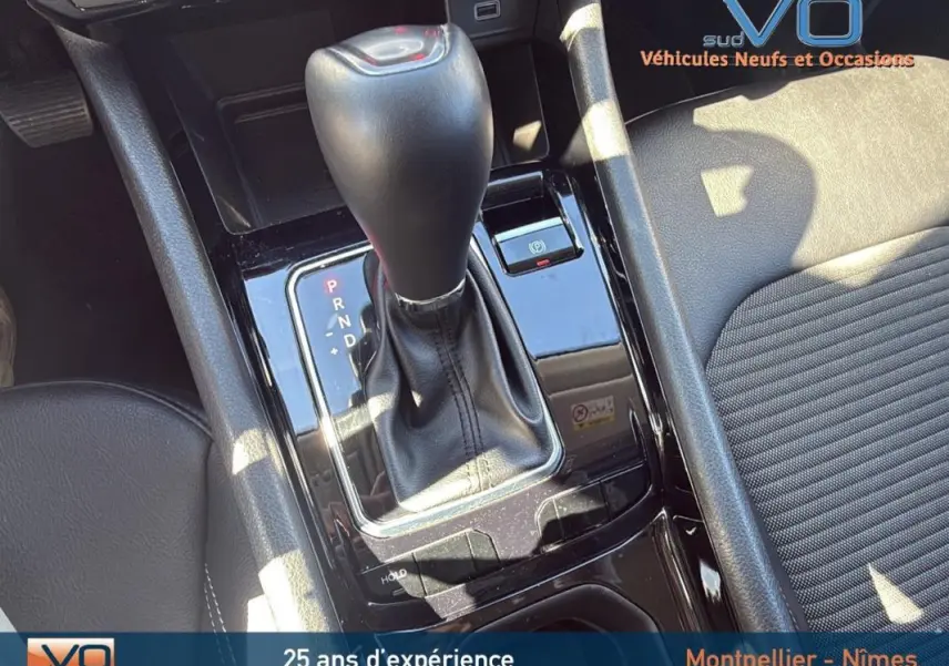 Gros plan sur la console centrale du Jeep Compass gris 2023 avec levier de vitesse automatique et accoudoir cuir noir.