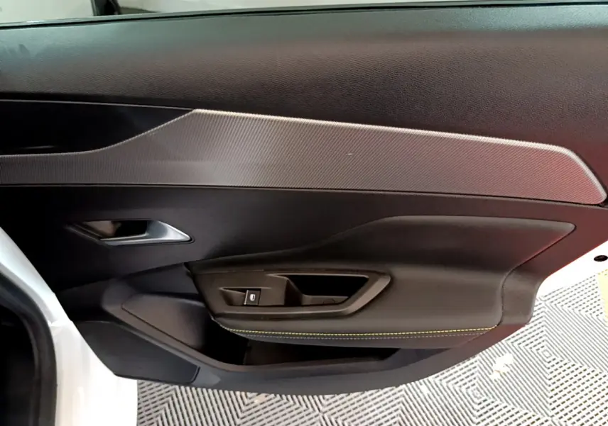 Vue intérieure côté gauche de la porte avant blanche d'une Peugeot 308 PHEV 180 E-EAT8 GT avec surpiqûres jaunes.