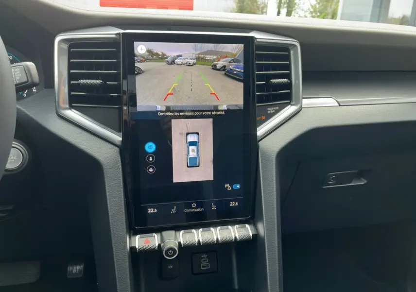 Vue rapprochée de la console centrale du Volkswagen Amarok noir 2025, écran tactile avec caméra 360° et commandes climatisation.