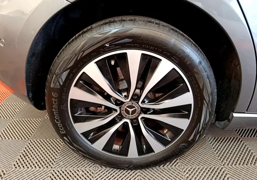 Gros plan sur la roue avant droite d'une Mercedes Classe A 250 e Business Line grise, jante alliage bicolore.