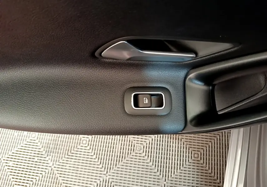 Détail de la poignée intérieure et bouton de verrouillage sur la porte côté gauche en cuir noir du Mercedes Classe A.