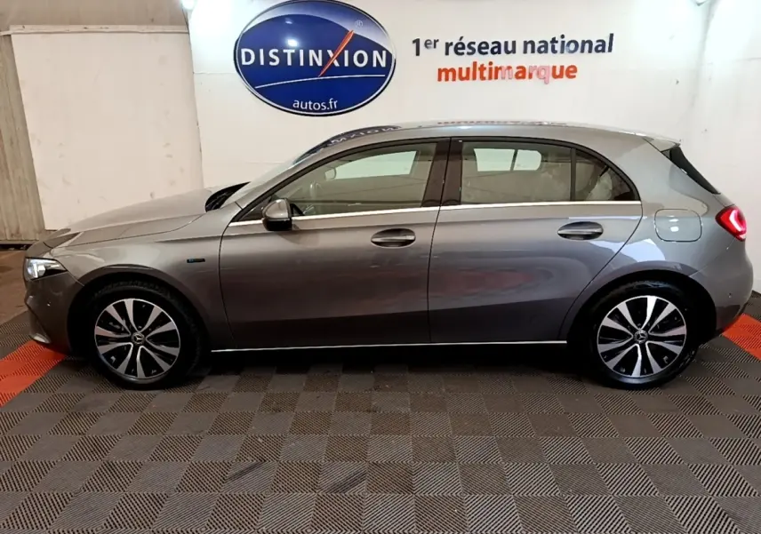 Vue latérale droite d'une Mercedes Classe A A 250 e Business Line grise, avec jantes alliage et feux arrière allumés.