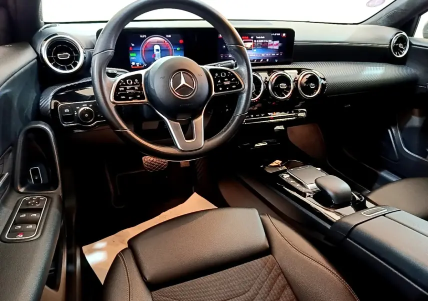 Intérieur noir de la Mercedes Classe A 250 e Business Line 2020, vue depuis le siège conducteur sur le tableau de bord et volant cuir multifonctions.