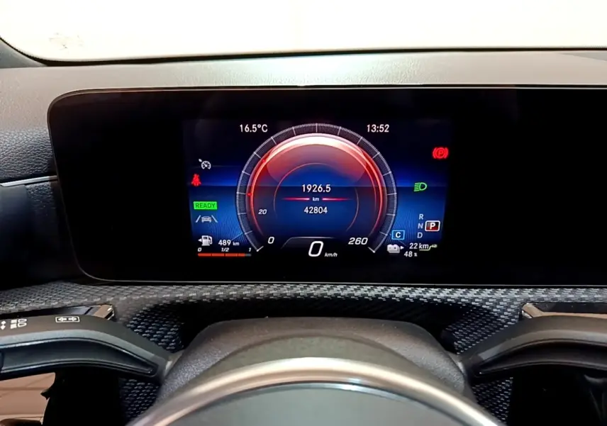 Vue rapprochée du tableau de bord numérique de la Mercedes Classe A 250 e Business Line 2020 avec affichage couleur et éléments de conduite.