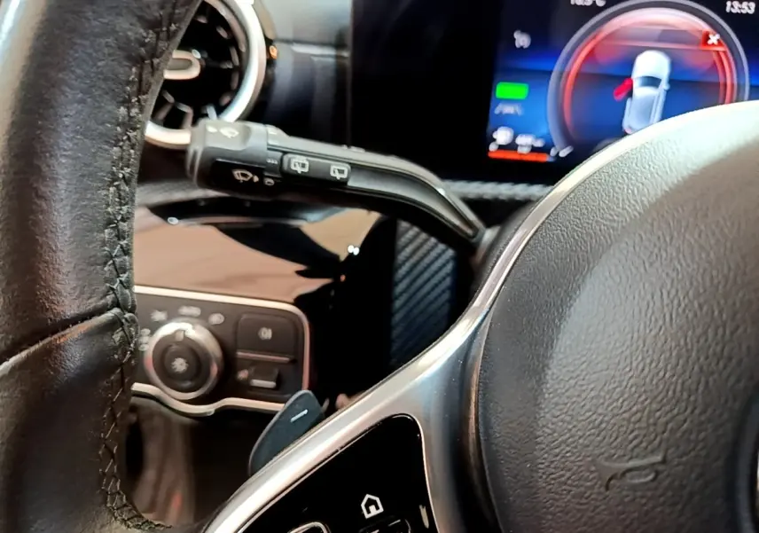 Vue rapprochée du volant cuir noir et du tableau de bord numérique de la Mercedes Classe A hybride rechargeable 2020.