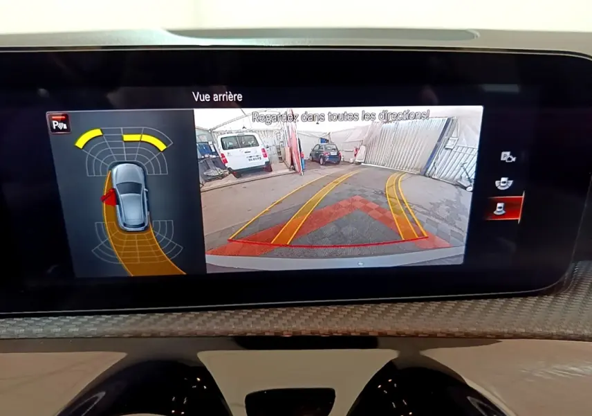 Écran de recul de la Mercedes Classe A 250 e Business Line montrant l’arrière avec lignes de guidage jaunes et rouges.