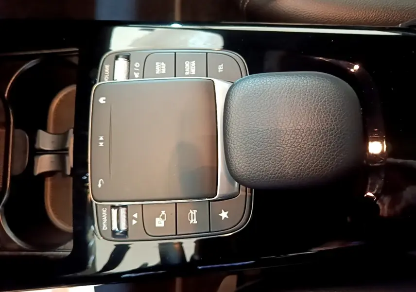 Vue rapprochée du pavé tactile et du repose-poignet en cuir noir de la console centrale d'une Mercedes Classe A 250 e Business Line.