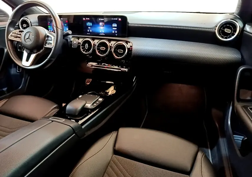 Vue intérieure côté conducteur de la Mercedes Classe A 250 e Business Line 2020, tableau de bord noir et volant cuir multifonctions.
