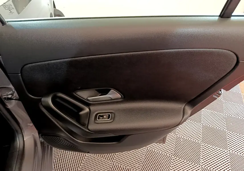 Vue intérieure de la porte côté gauche noire de la Mercedes Classe A 250 e Business Line 2020 avec commande de vitre électrique.