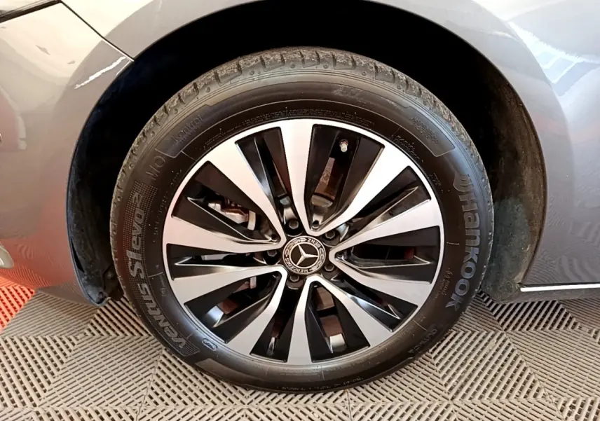 Gros plan sur la roue avant gauche d'une Mercedes Classe A 250 e Business Line gris métallisé avec jante alliage bicolore.