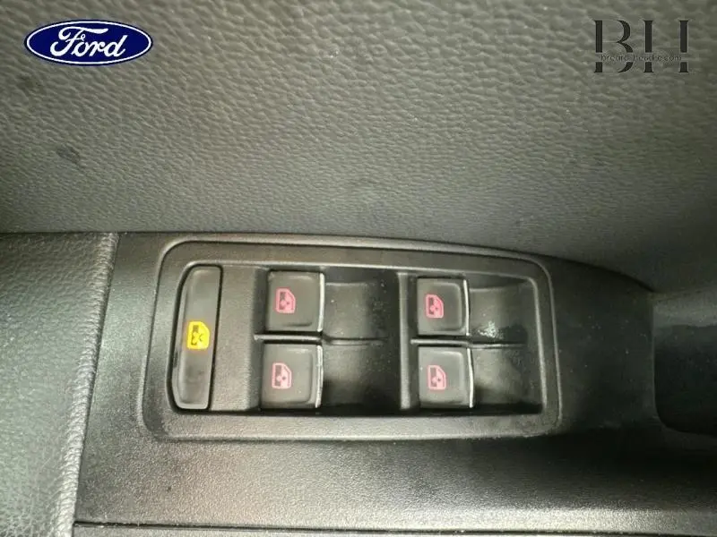 Gros plan sur les commandes des vitres électriques côté conducteur d’un SEAT Ateca blanc Nevada Métal.