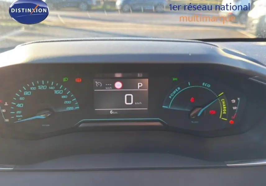 Vue rapprochée du tableau de bord numérique de la Peugeot 208 hybride 2025, affichant vitesse et indicateurs eco.