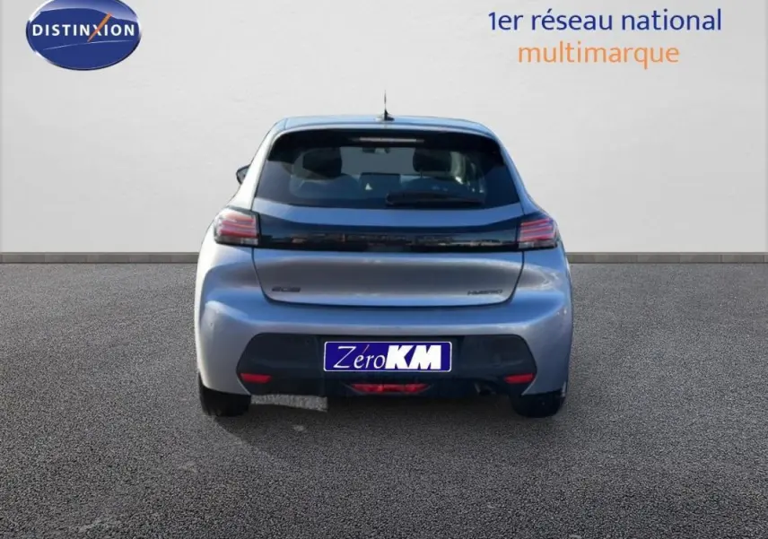 Vue arrière d'une Peugeot 208 gris 1.2 Hybrid 100ch avec feux LED et logo noir brillant sur un sol goudronné.
